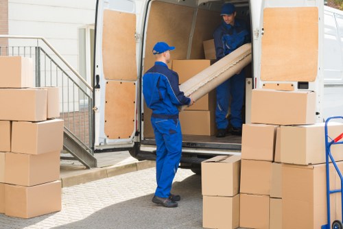 Professional house movers assisting a Chelsea home move with boxes and furniture