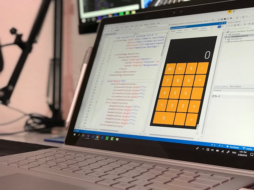 A close-up view of a laptop screen displaying computer code on the left side and a large orange calculator interface on the right side, including basic functions such as addition, subtraction, multipl